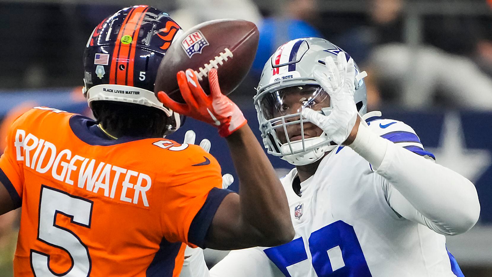 Denver Broncos quarterback Teddy Bridgewater (5) throws a pas under pressure from Dallas...