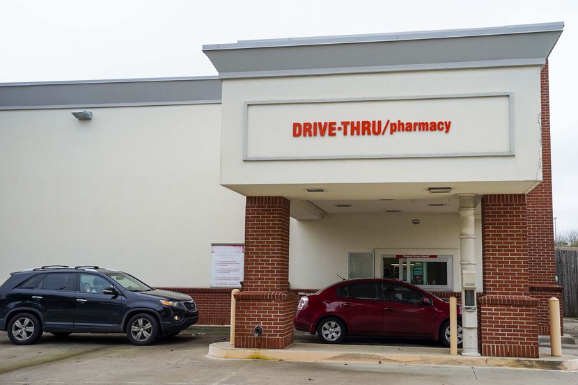 Cars line up for drive-thru service at a CVS pharmacy on Belt Line Road in Dallas on March...