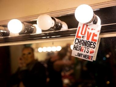 A sign that says “Love changes hearts… and hearts” on the mirror as the performers get ready...