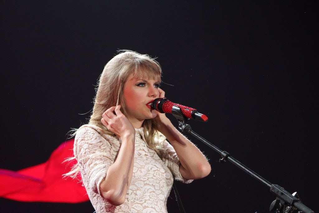 Appearing to be dressed in a cape, Taylor Swift performs to the delight of her fans in...