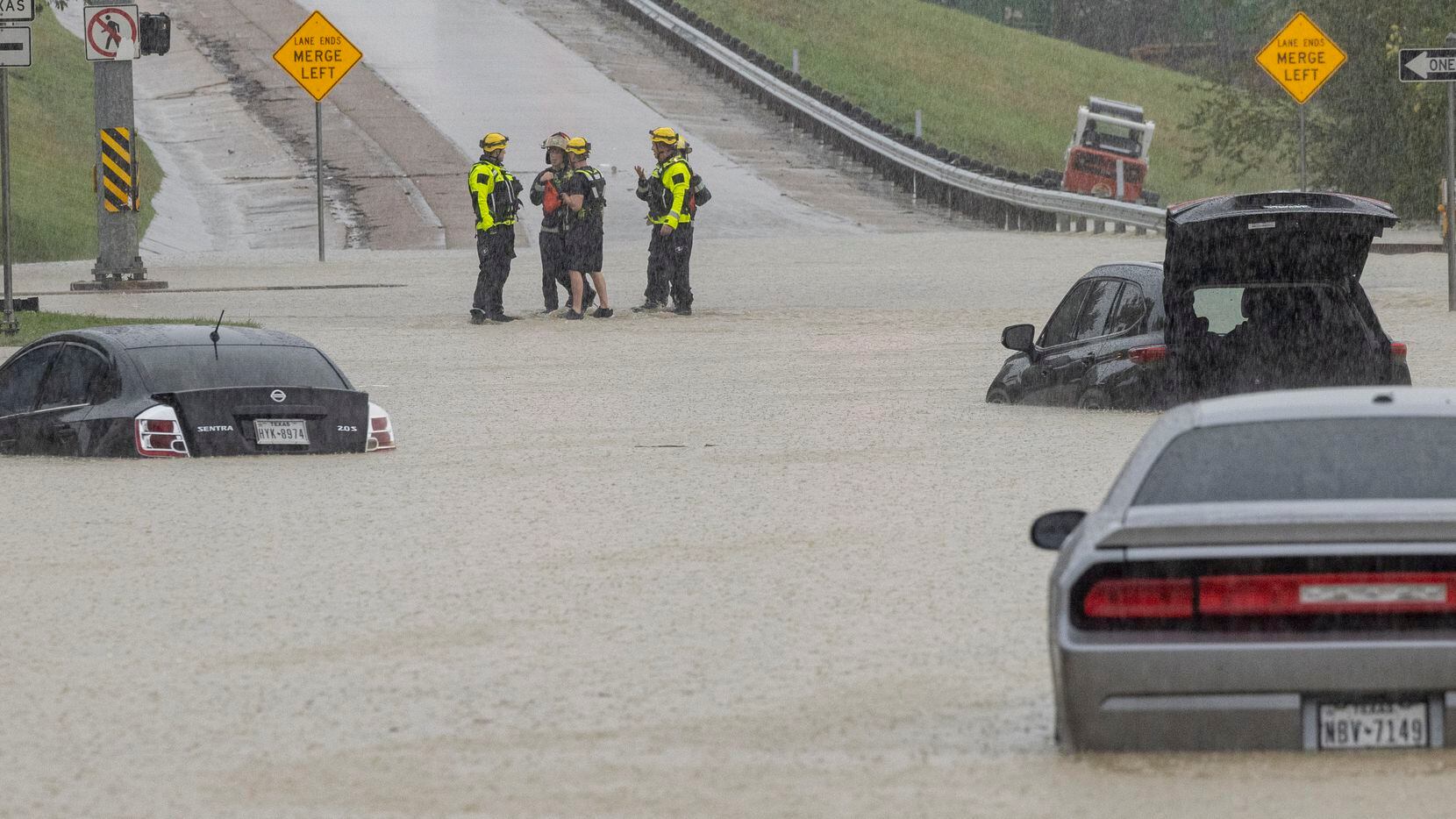 Members of the Mesquite Fire Department survey the stalled cars on the Interstate 635...