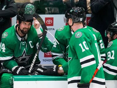 Dallas Stars left wing Jamie Benn (14) puts on a hat thrown on the ice by a fan after he scored a goal for a hat trick during the third period of an NHL game between the Dallas Stars and the Carolina Hurricanes on Tuesday, February 11, 2020 at American Airlines Center in Dallas.