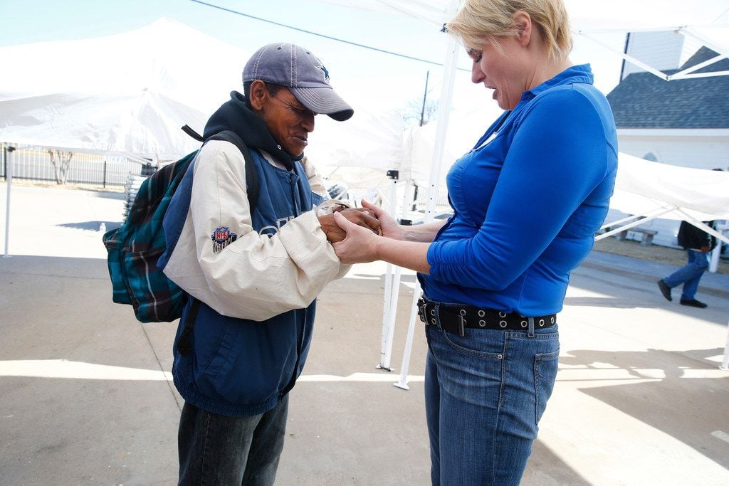 Sarah Slack (right) prayed with Arhonda Cokefield after the service at the SoupMobile Church for the homeless in Dallas on Feb. 4, 2018.