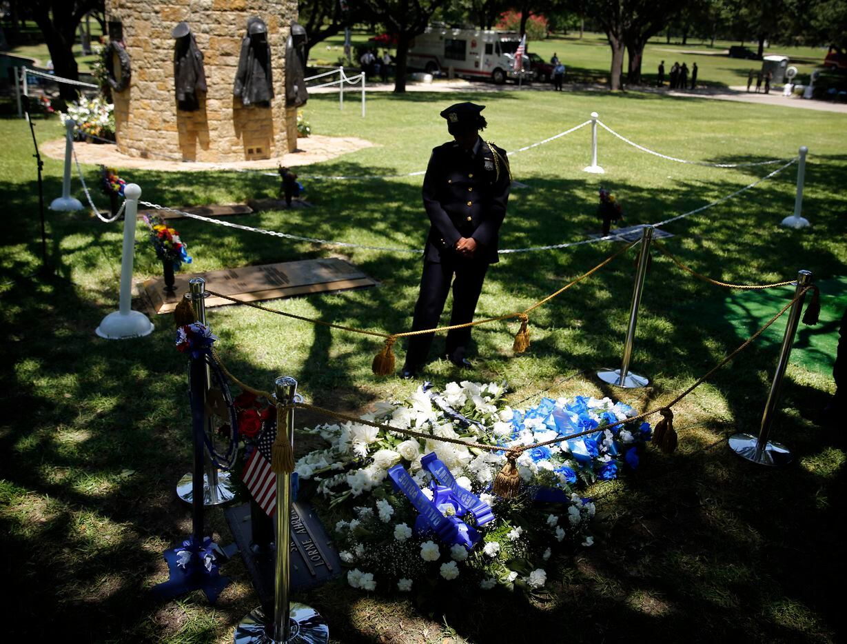 New York State Courts officer Laura Collins pauses to reflect upon the grave of Dallas...