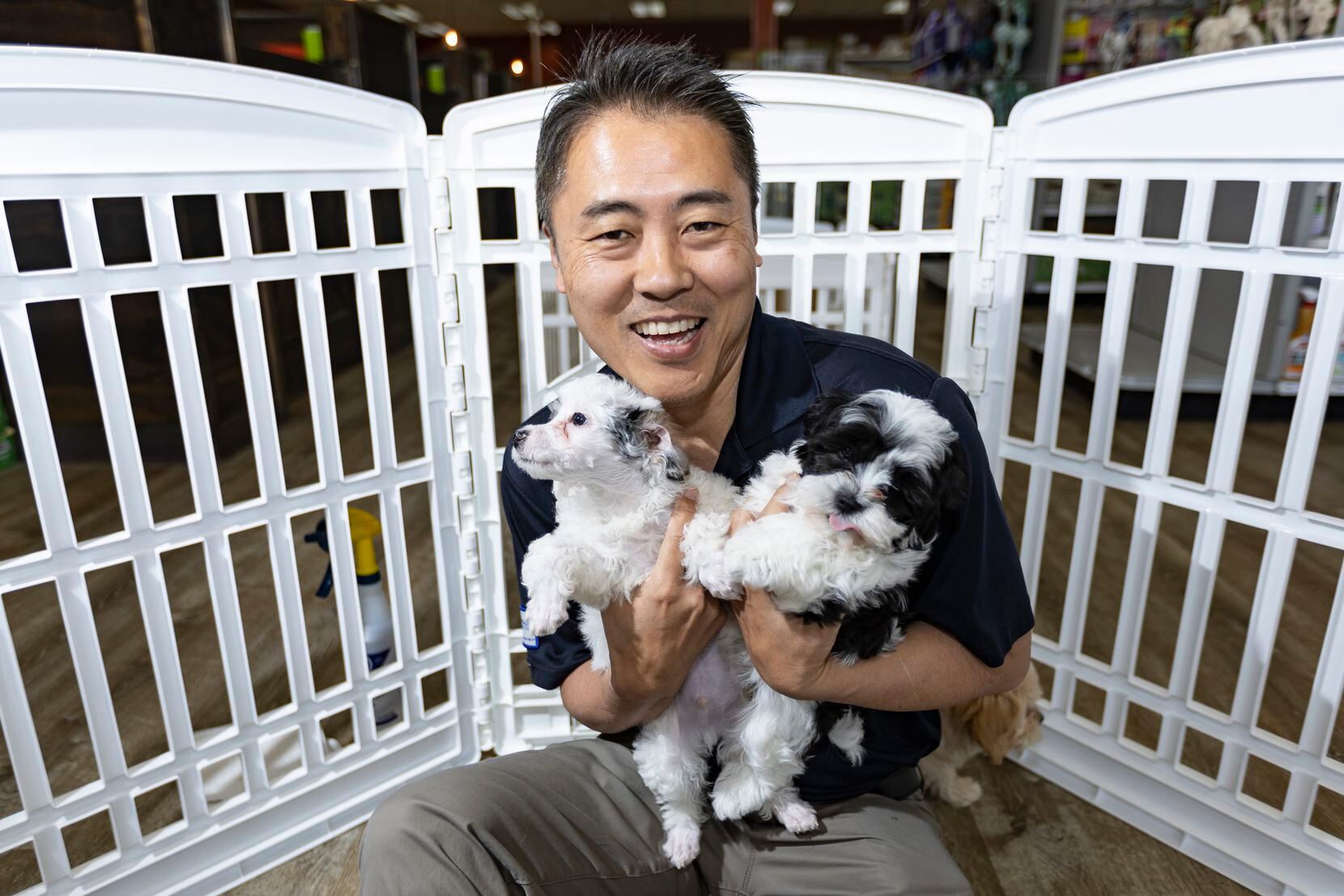 Petland owner Jay Suk with two puppies for sale at his store in Dallas.