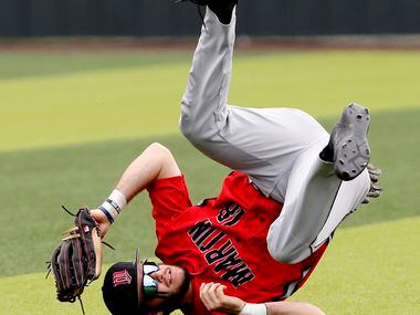 Martin right fielder Dawson Duerby (18) hangs onto a running catch for an out in the fifth...