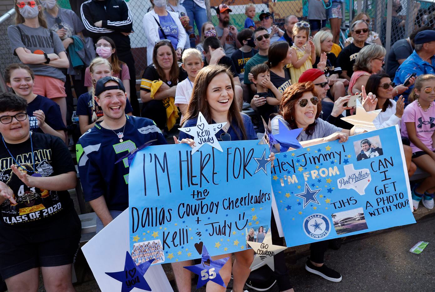 Dallas Cowboys fans Alicia Boudreaux  (center, left) and Josephine Boudreaux of Canton, Ohio cheer with signs along the Canton Repository Grand Parade in downtown Canton, Saturday, August 7, 2021. The parade honored newly elected and former members of the Hall, including newcomers and former Dallas Cowboys players Cliff Harris, Drew Pearson and head coach Jimmy Johnson. (Tom Fox/The Dallas Morning News)
