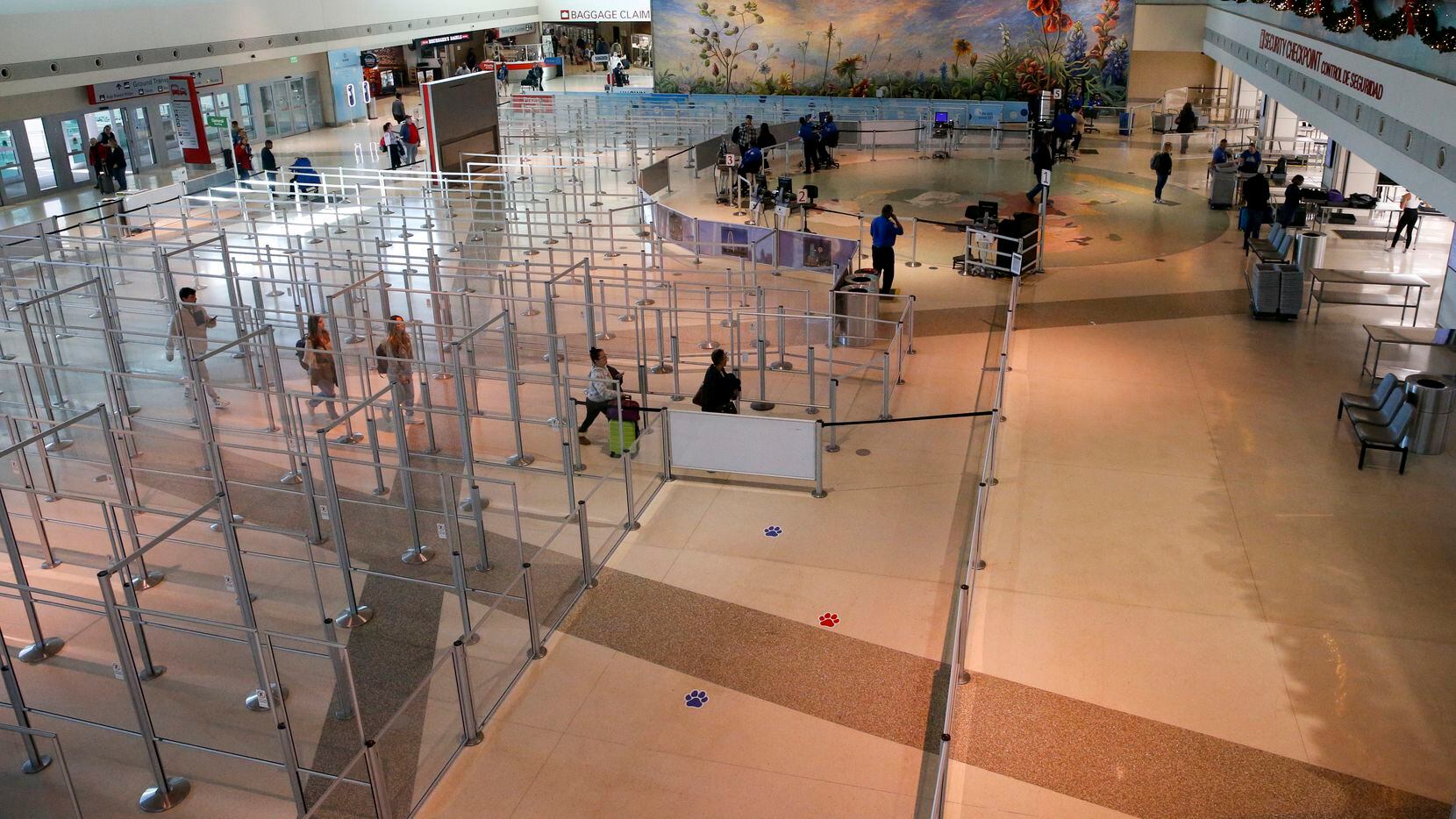 A group of travelers make their way through a mostly empty TSA security checkpoint at Love...