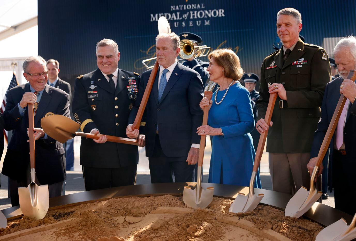Former President George W. Bush (center) tossed his shovel over his shoulder after he and...