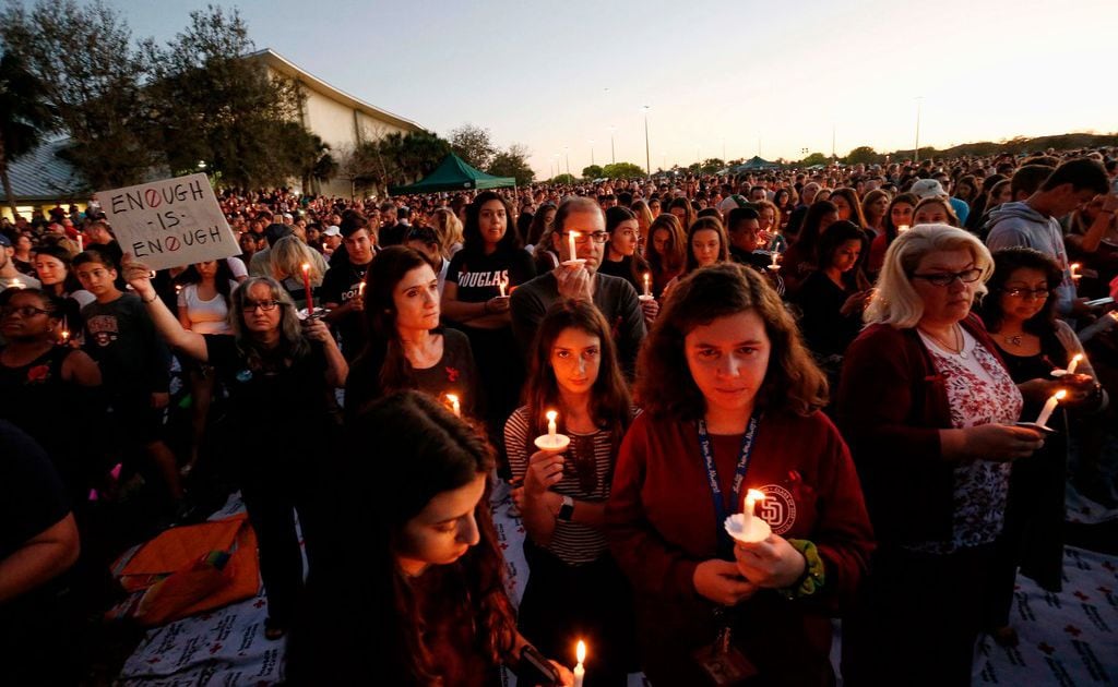 TOPSHOT - Thousands of mourners hold candles during a candlelight vigil for victims of the Marjory Stoneman Douglas High School shooting in Parkland, Fla. on Feb. 15, 2018.