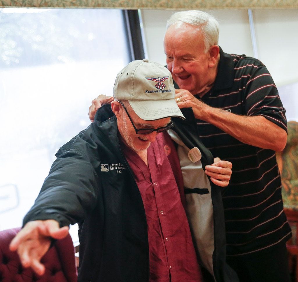 Retired major league umpire Larry Barnett, who has visited hospitalized veterans since 1977, presents a jacket to Russell Moore, a Navy veteran, during a visit to the VA North Texas Health Care System on Thursday, Aug. 8, in Dallas.