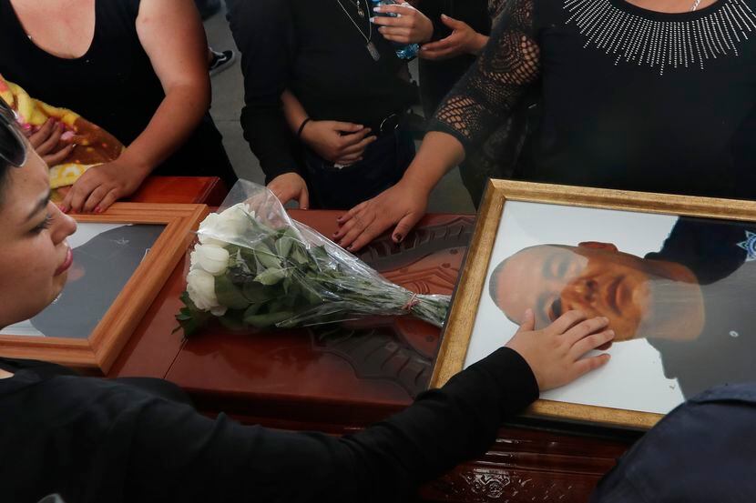 Familiares tocan el ataúd y la foto del policía Pablo Sergio Reynel, quien fue asesinado en...