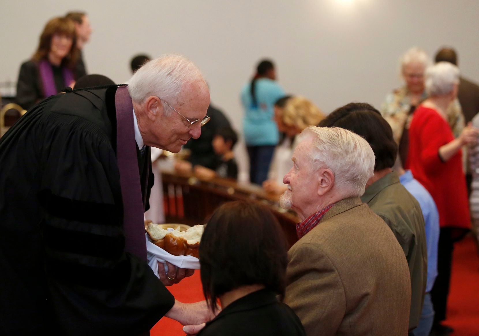 Bill Bryan serves communion at Dallas' Grace United Methodist Church, where he was pastor...