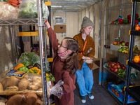 Finley Miles, 8, left, and her mother Hilary Miles, stock shelves with fruits and veggies inside the new cold storage facility for The Oak Cliff Veggie Project and the 4DWN Project during a soft opening for the storage tank at the 4DWN Skatepark in Dallas, on Monday.