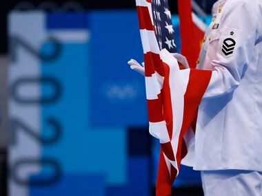 Flags are hoisted in the air during the medal ceremony for the women’s 3 meter springboard...