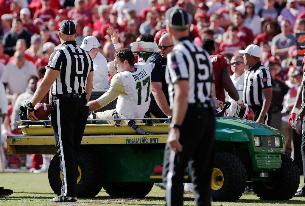 Baylor quarterback Seth Russell (17) waves to the crowd as he is carted off the field after...