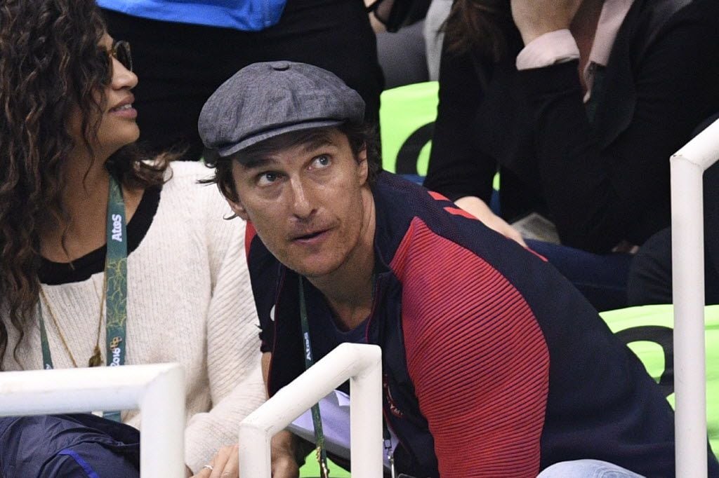 US actor Matthew McConaughey (R) and his wife Camila Alves watch the swimming events at the...