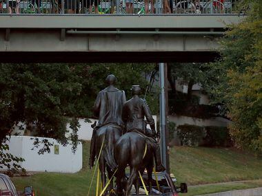People take pictures of a truck carrying the Robert E. Lee statue from Katy Trail at Robert...