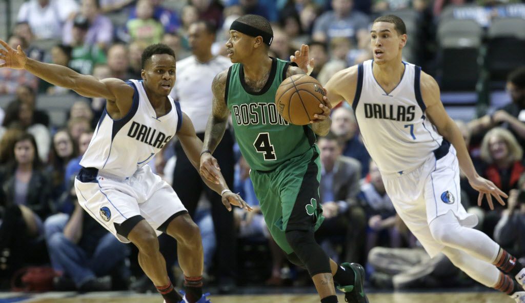 Boston Celtics guard Isaiah Thomas (4) dribbles against Dallas Mavericks defenders Yogi...