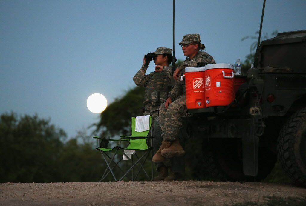  Texas National Guard troops watch for illegal immigrant crossings as a full moon rises near...