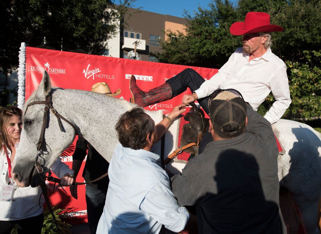 Richard Branson dismounts from a horse after arriving at the ground breaking for his hotel...