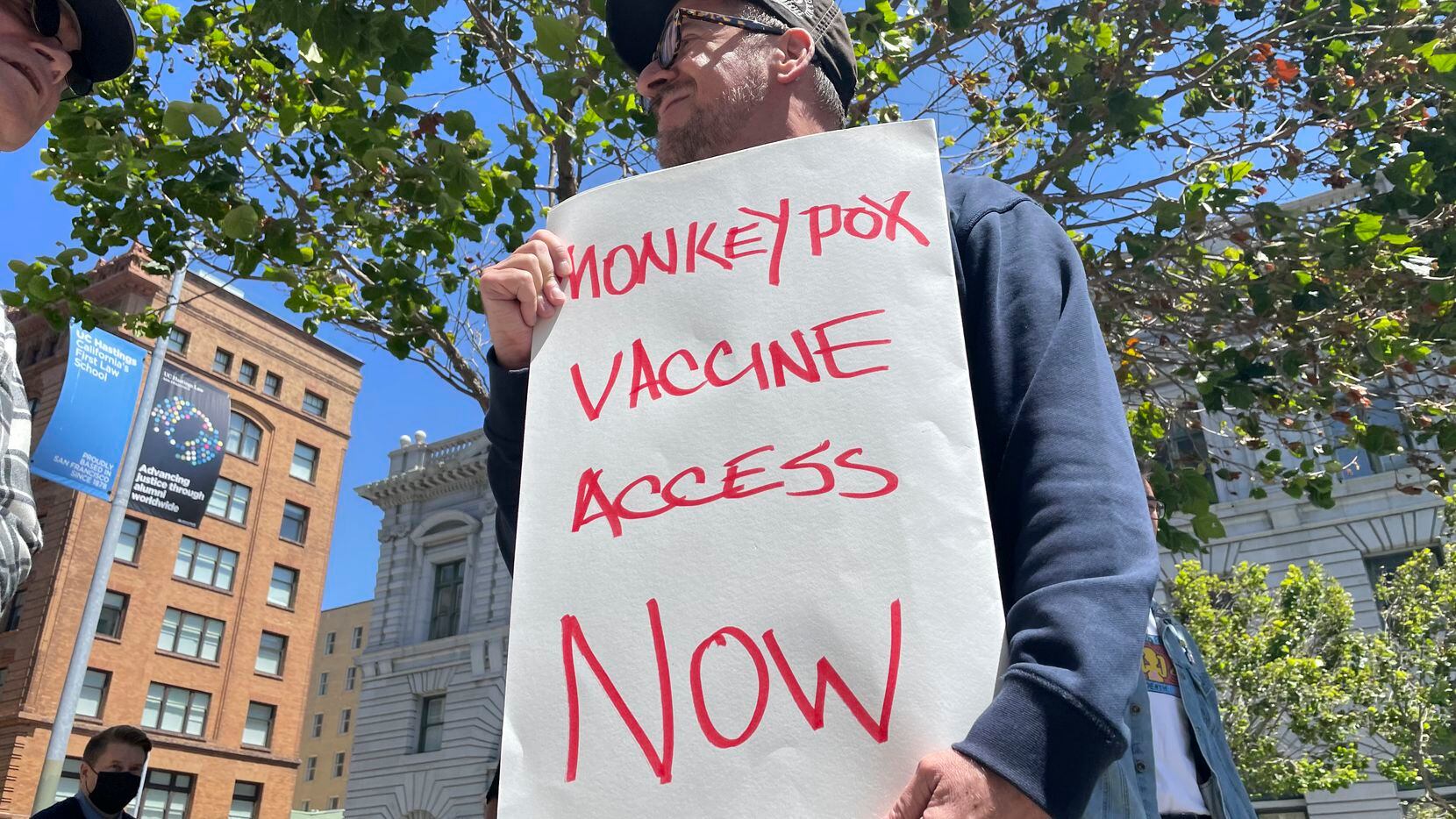 Un hombre sostiene un cartel en el que exige que se agilice el acceso a las vacunas contra...