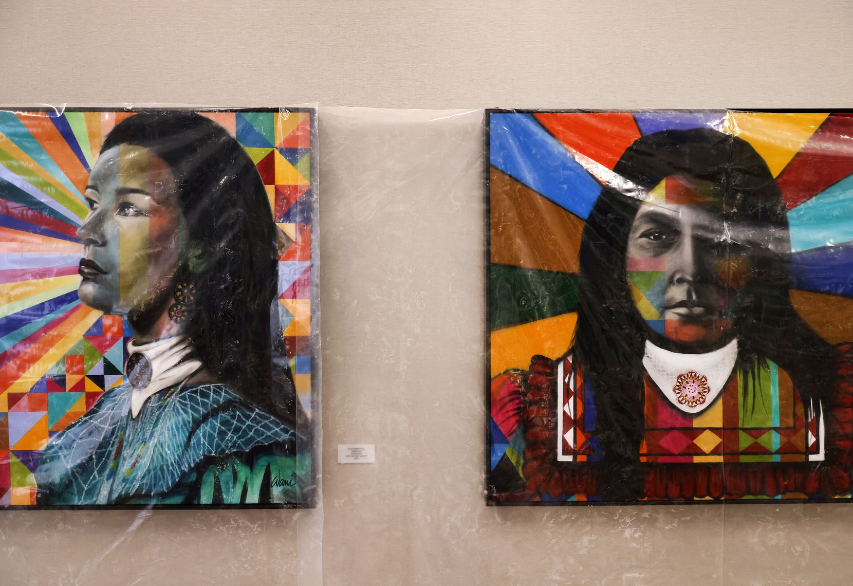 Paintings of Native Americans by Choctaw tribal artists hang protected with plastic in the...