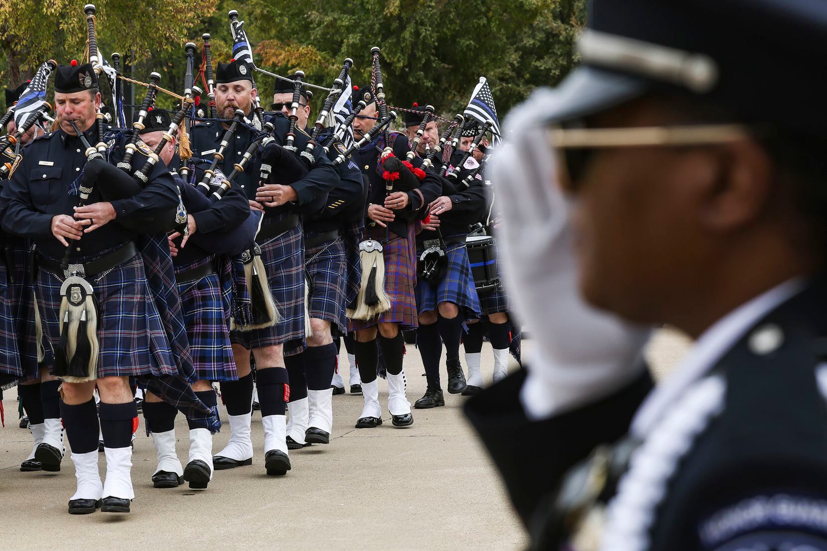 Amazing grace is played on the bagpipes ahead of the hearse holding Grand Prairie police...