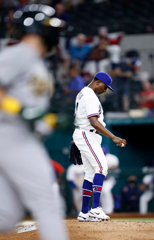 Texas Rangers relief pitcher Jharel Cotton (45) reacts after giving up a home run to Oakland Athletics Seth Brown (foreground) during the ninth inning at Globe Life Field in Arlington, Saturday, August 14, 2021.(Tom Fox/The Dallas Morning News)