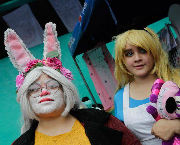 Cosplay enthusiasts are dressed as characters from Alice in Wonderland.
 