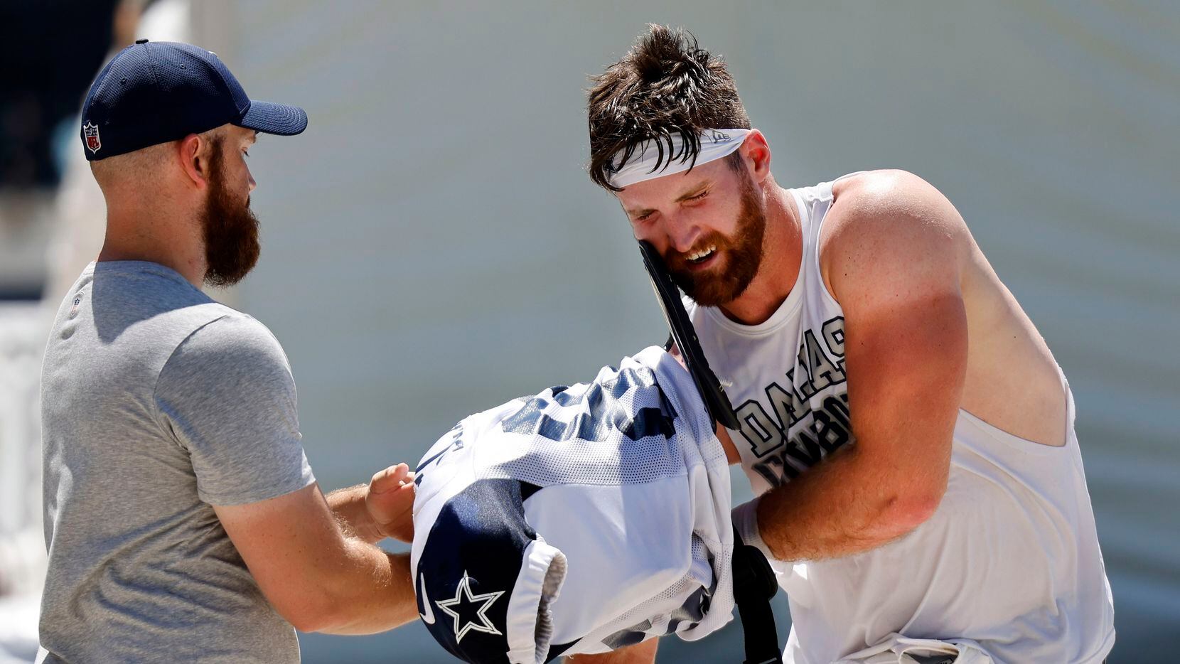 Dallas Cowboys tight end Dalton Schultz has help shedding his shoulder pads following...