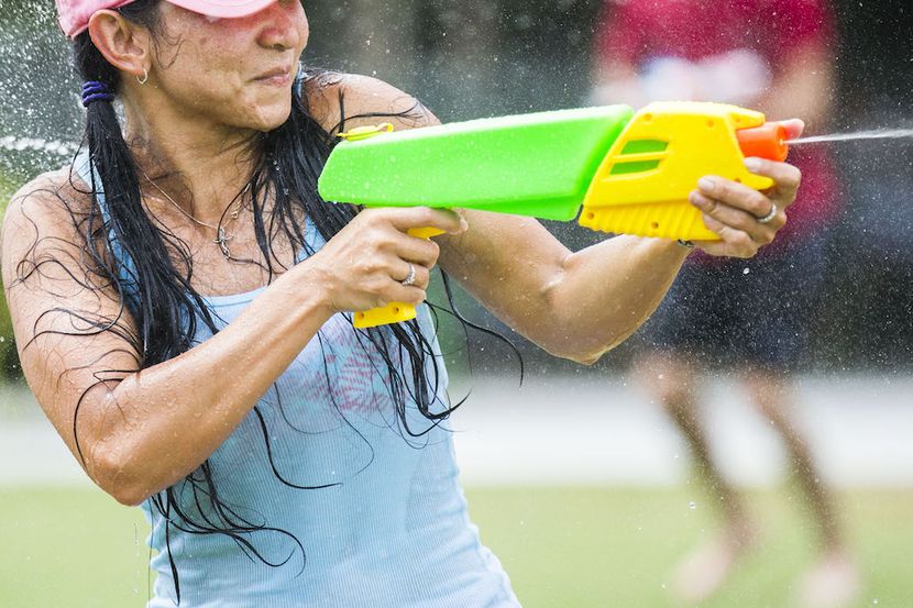 Tana Roeun participates in a massive water gun fight at Klyde Warren Park.