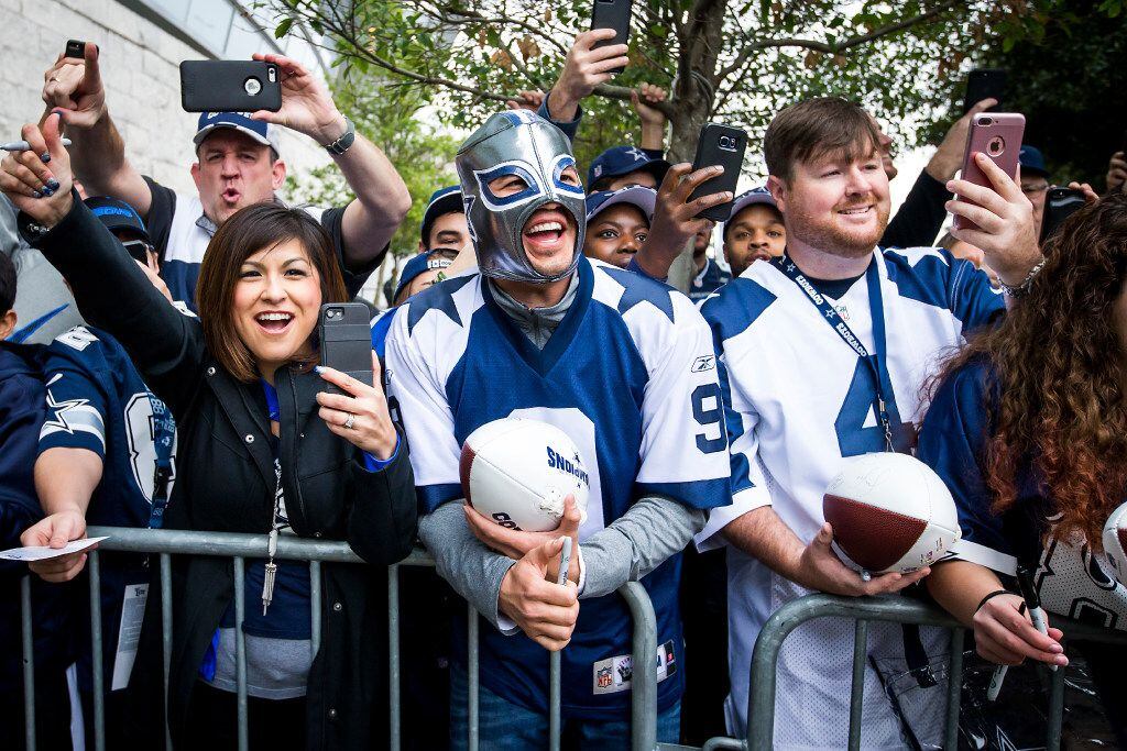 Fans cheer for Dallas Cowboys players as they arrive at the stadium before an NFC divisional...