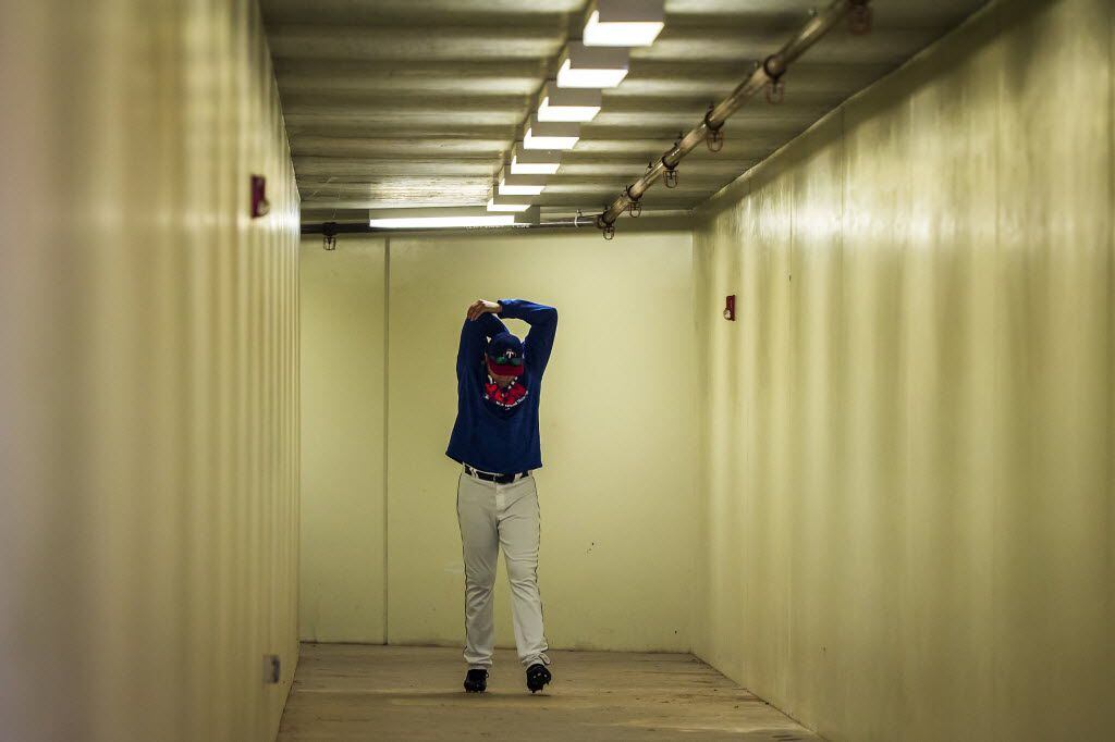 Texas Rangers pitcher A.J. Griffin stretches as he walks through a tunnel to the field...