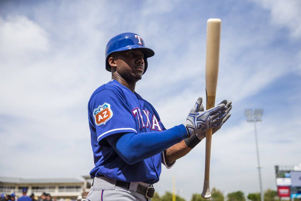 Texas Rangers oufielder Lewis Brinson steps into the on deck circle during a spring training...