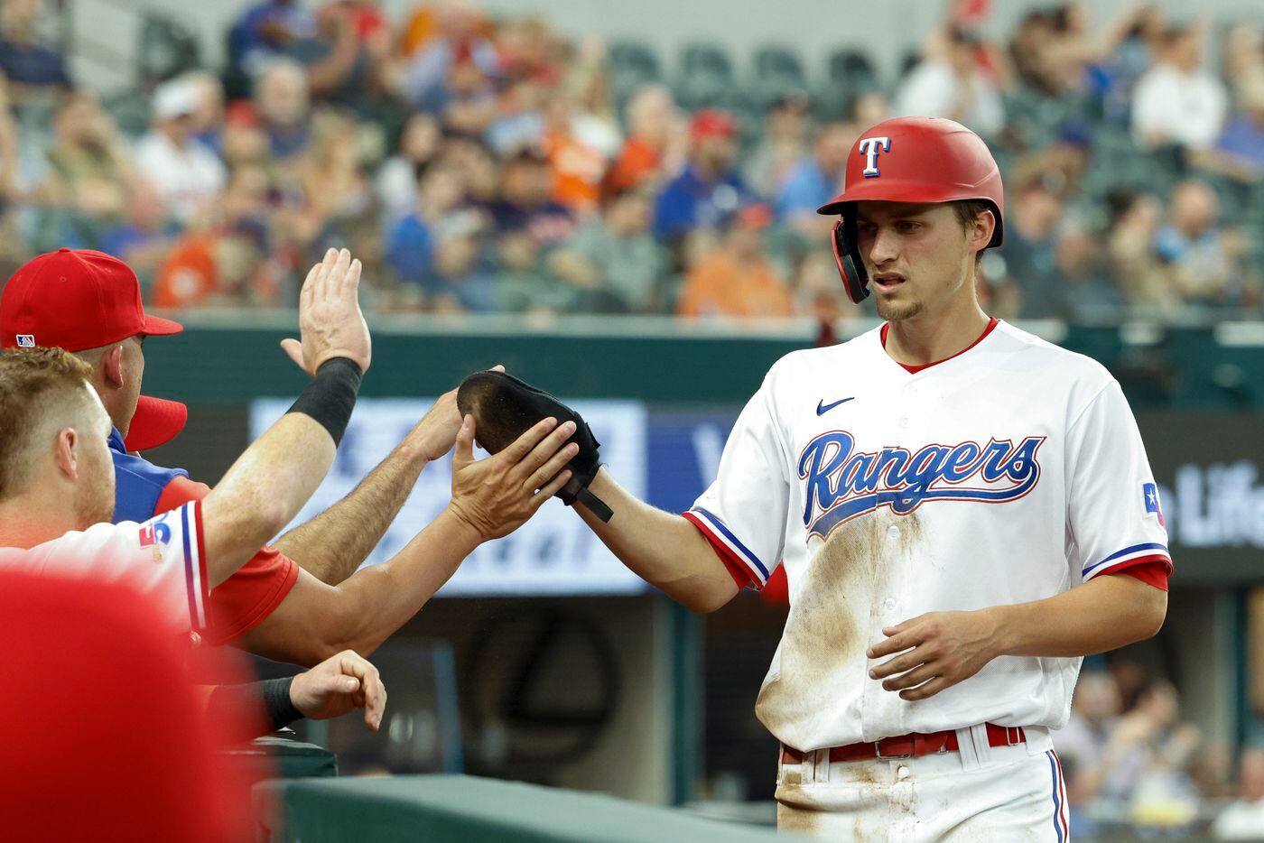 Texas Rangers shortstop Corey Seager (5) high-fives his teammates after scoring a run during...