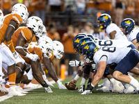 The Texas defense lines up against the West Virginia offense during the second half of an...