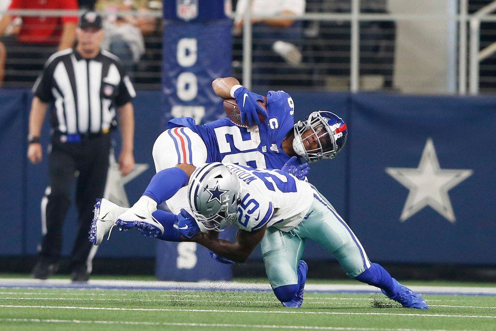 Dallas Cowboys free safety Xavier Woods (25) tackles New York Giants running back Saquon...