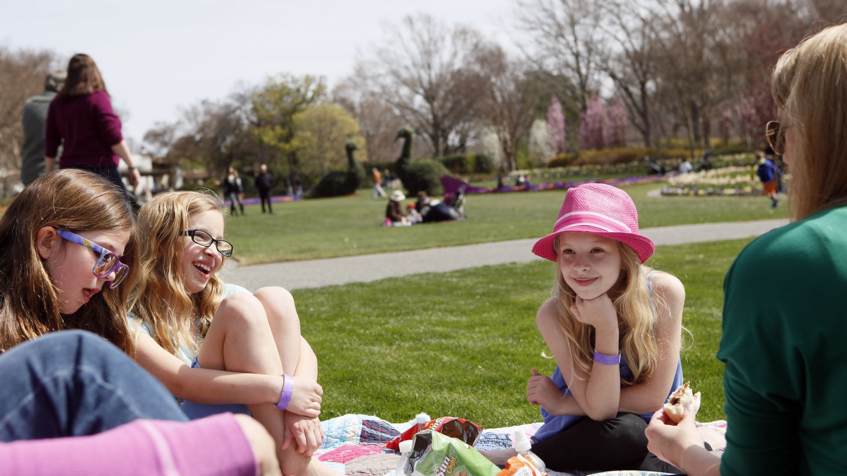 Alexis Dwyer, Isabella Kelley and Lilly Kelley sit with their mothers during a picnic in the...
