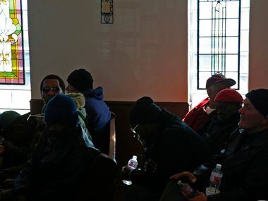 People pray during worship service at SoupMobile Church for the homeless in Dallas on Feb....