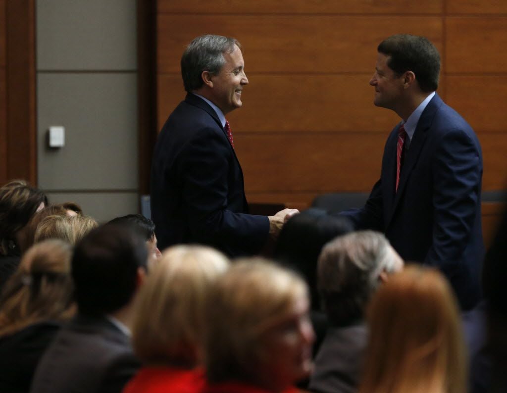 Texas Attorney General Ken Paxton shakes hands with his attorney Bill Mateja after entering...