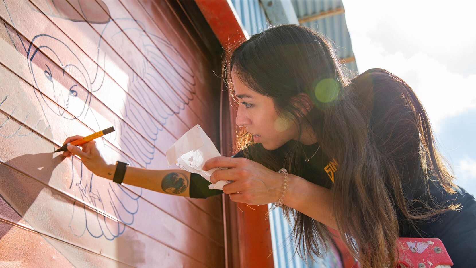 Artist Rose Rodriguez works on her mural on as part of The Wild West Mural Fest in Dallas on...