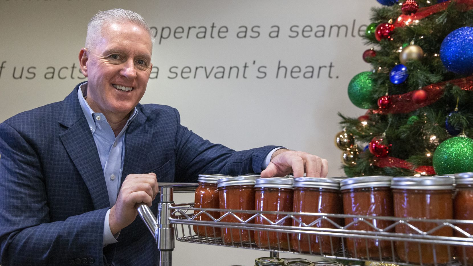 President and CEO Lynn Davis poses for a portrait with jars of his homemade salsa at Dallas...