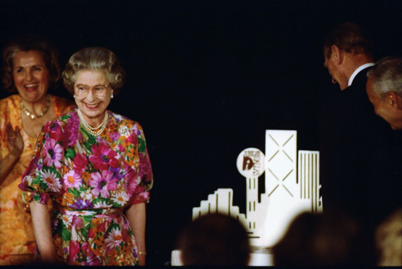 Dallas Mayor Annette Strauss looks on as Queen Elizabeth II and Prince Philip prepare to cut...