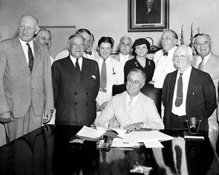 In this Aug. 14, 1935, file photo President Franklin Roosevelt signs the Social Security...