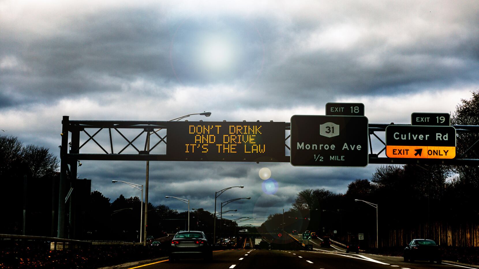 A highway sign that reads "don't drink and drive, it's the law"