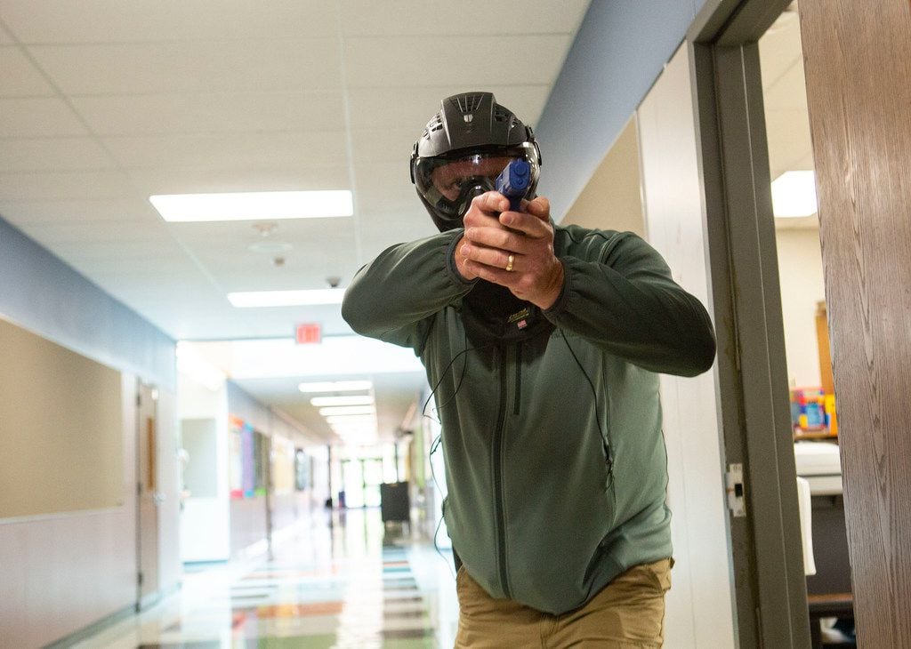 A Texas school employee training to become an armed school marshal steps into the hallway after clearing out a classroom, part of a practice drill at Windermere Elementary School in Pflugerville, Texas on August 10, 2018. (Thao Nguyen/Special Contributor).