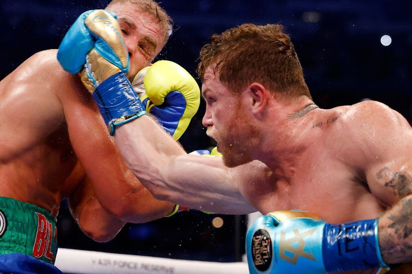 El boxeador mexicano Saúl Canelo Álvarez (der) lanza un golpe a Billy Joe Saunders durante...