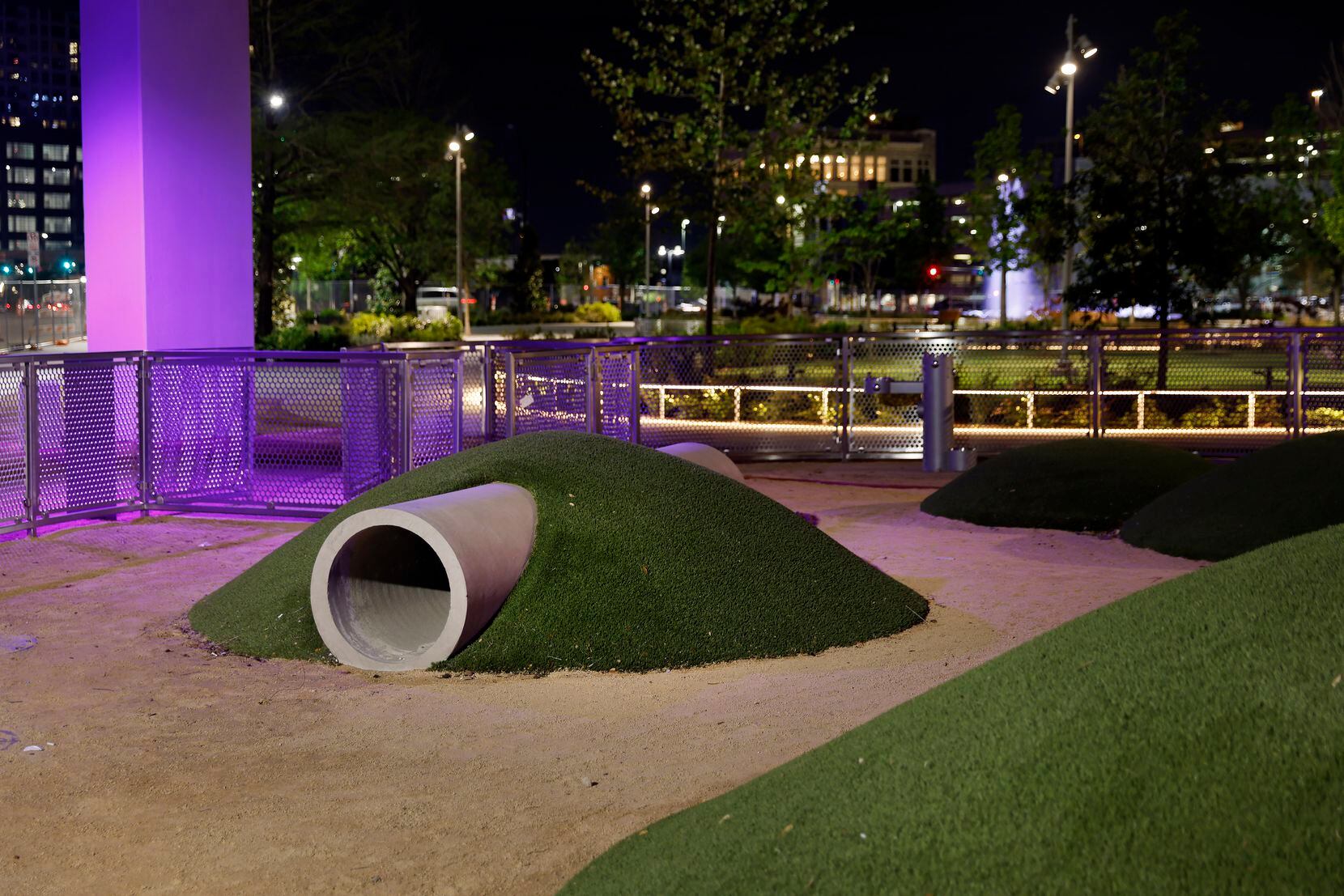 Artificial grass covers mounds in an enclosed dog park inside the newly constructed...