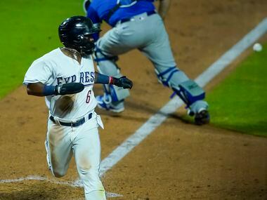 Round Rock Express infielder Yonny Hernandez scores ahead of the throw to Oklahoma City...